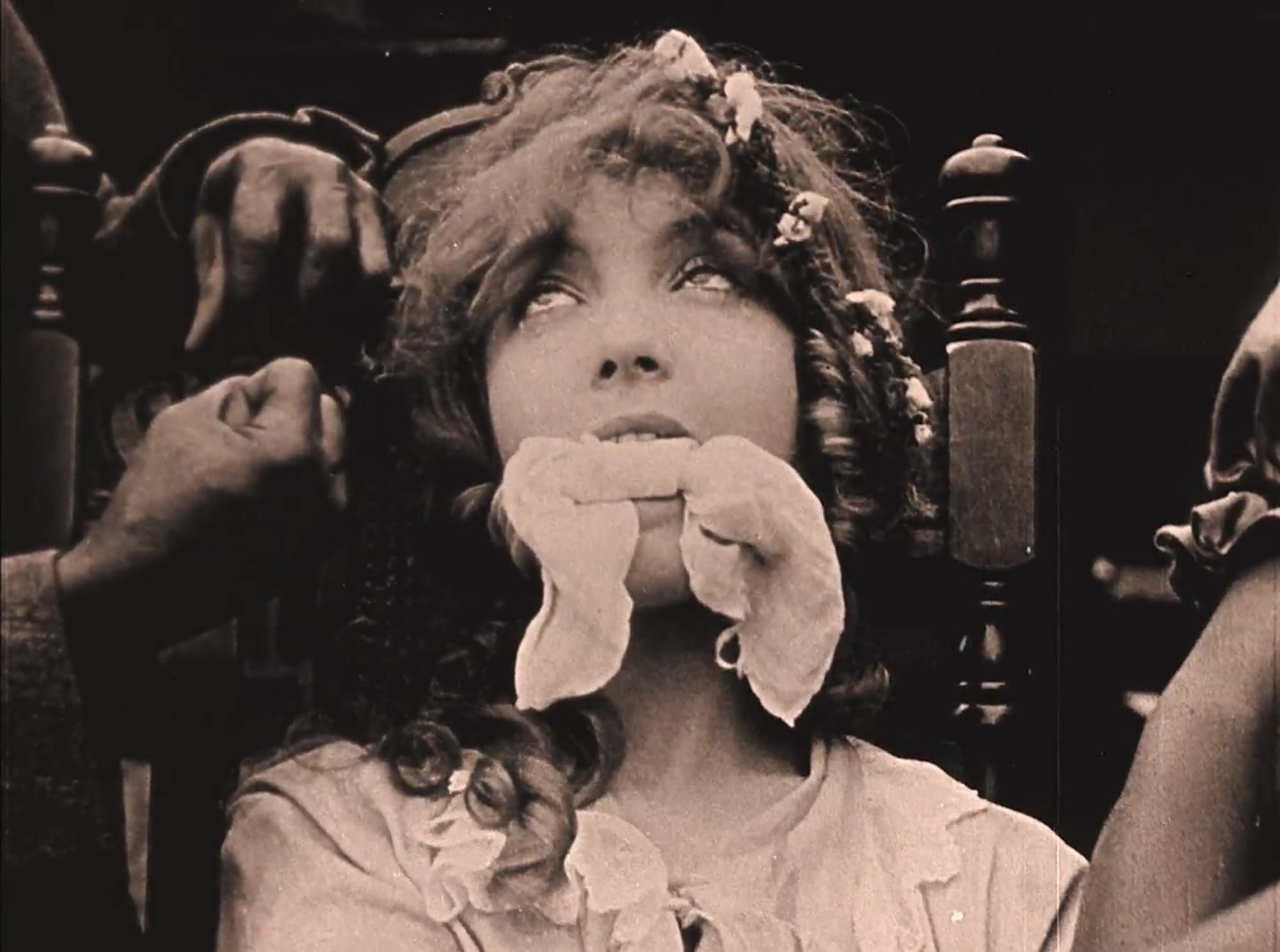 Bound and gagged, a white actress looks heavenward as a crowd of white actors in blackface threaten to rape her. From “Birth of a Nation,” D.W. Griffith’s silent film lionizing the Ku Klux Klan as defenders of southern womanhood.